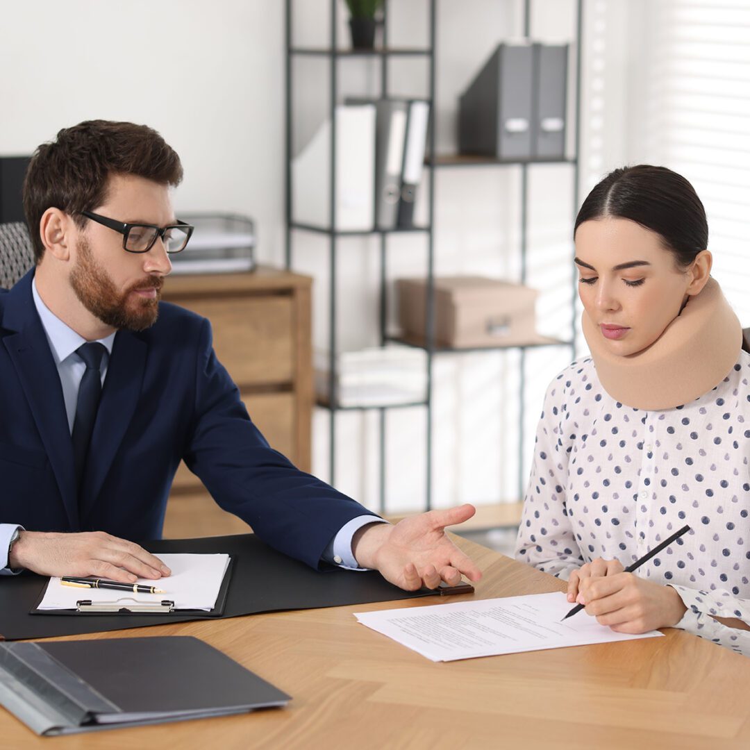 A man comforts a distressed woman holding a pen and paper.