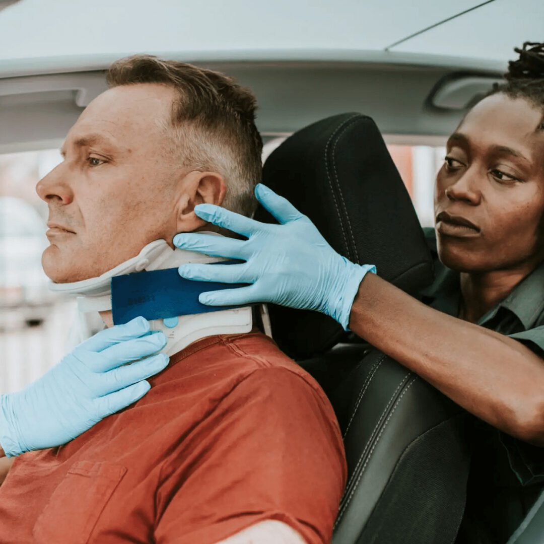 A man receiving a neck brace from a medical professional.