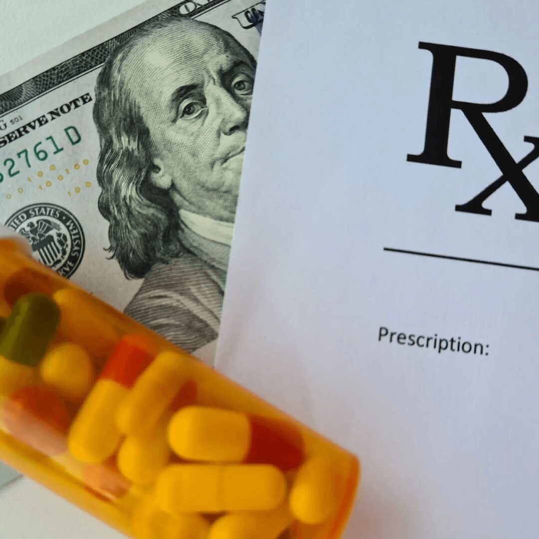 Prescription medication with pills and hundred-dollar bill.