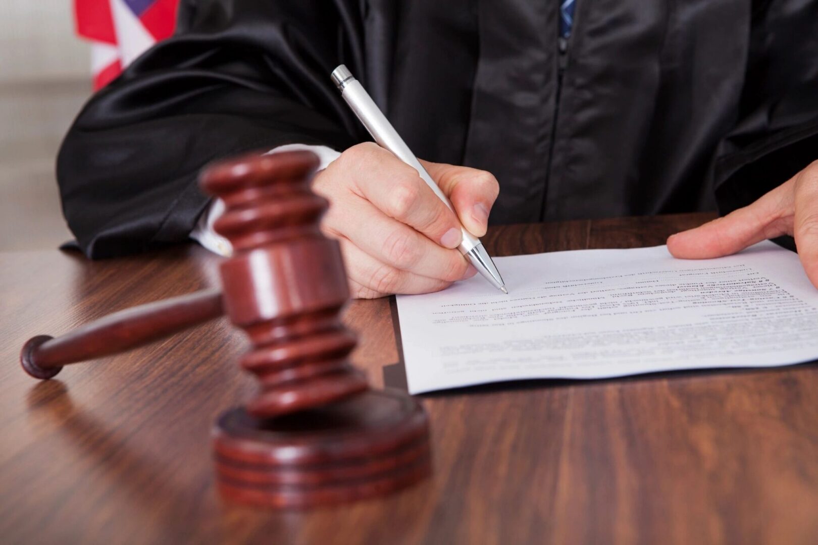Gavel foreground, judge signing documents
